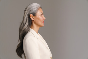 Mature asian woman with white hair posing in profile