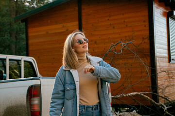 A girl in a hat on the background of a house in the forest