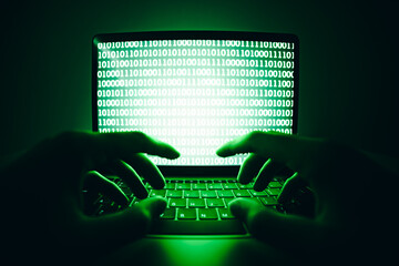Closeup of hacker is using the laptop computer to coding virus or malware for hacking internet...
