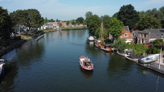 A pleasure boat sails up the Vecht at Weesp in Netherlands