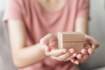 Close up of woman hands holding a small gift box. Small present box in the woman hands..