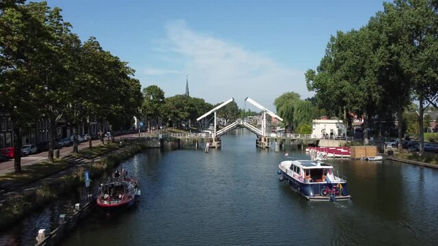 A pleasure boat sails up the Vecht towards a bridge at Weesp in Netherlands