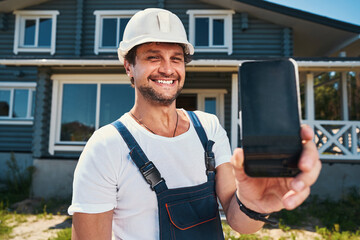 Proud housebuilder showing phone cover in hand