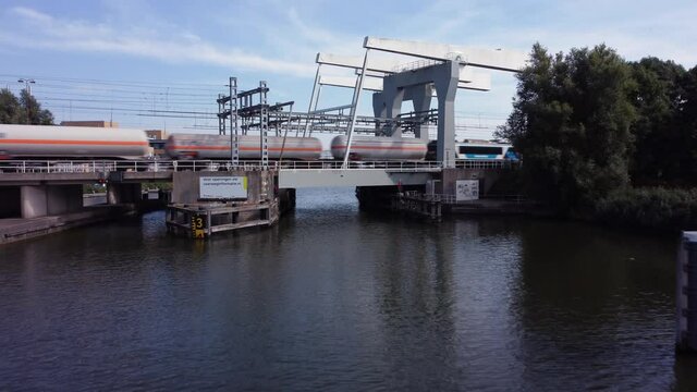 Railway bridge over river Vecht in Holland in the city of Weesp, cargo train passing
