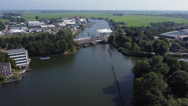 Railway bridge over river Vecht in Holland in the city of Weesp, Dutch yellow train passing