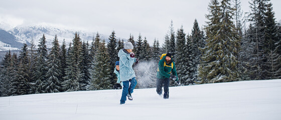 Family with small daughter having fun outdoors in winter nature, Tatra mountains Slovakia.