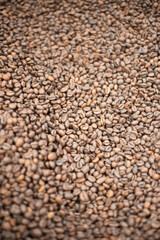 Close-up of roasted coffee beans. Fresh aromatic coffee ready for sale. Production, industry, manufacturing process concept