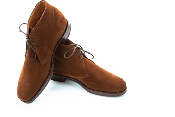 Male Footwear Concepts.Closeup of Pair of Mens Brown Suede Chukka Boots Placed One Over Another On White Background.