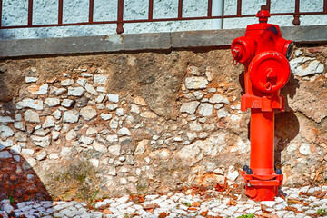 Closeup View of Old Styled Red Fire Cock Hydrant Against of Wall Located On One of The Streets in...