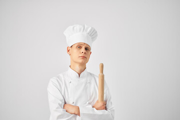 a man in a chef's uniform holding a rolling pin cooking food restaurant kitchen