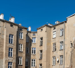 run-down and shabby apartment building block in Eastern Europe under a blue sky - obrazy, fototapety, plakaty