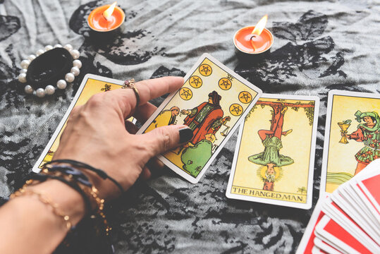 Show fortune tellers of hands holding tarot cards and tarot reader with candle light on the table, Performing readings magical performances, Things mystical astrologists forecasting concept