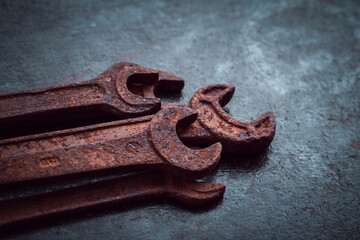 Vintage wrenches covered with rust on a dark background