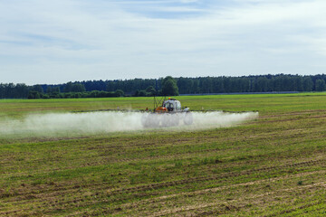 Fototapeta premium Tractor sprays liquid chemical fertilizers