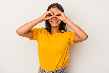 Young latin woman isolated on white background  showing okay sign over eyes