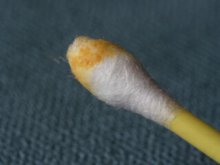 Earwax on a cotton swab, macro photo. Earwax, also known by the medical term cerumen, is a brown, orange, red, yellowish or gray waxy substance secreted in the ear canal of humans and other mammals.