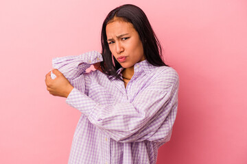 Young latin woman isolated on pink background  having a neck pain due to stress, massaging and touching it with hand.