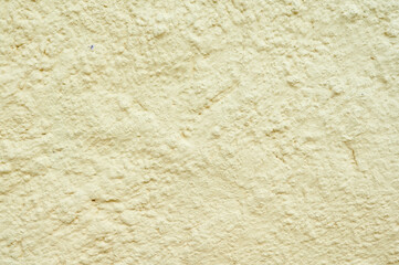 Yellow colored concrete wall background texture with soft lighting