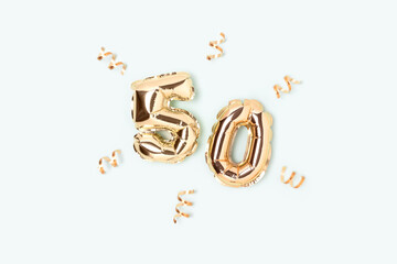 Number 50 golden air balloons with confetti on a blue pastel background.