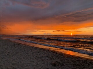 Fototapeta na wymiar Fantastic orange and purple sunset at the sandy beach, paradise, evening sea background