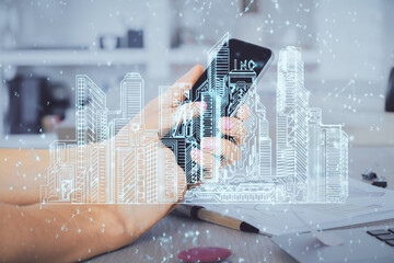 Double exposure of man's hands holding and using a digital device and city drawing.