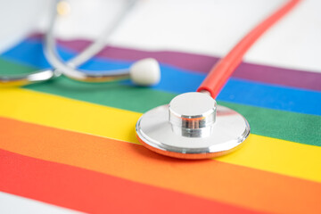 Red stethoscope on rainbow flag background, symbol of LGBT pride month celebrate annual in June social, symbol of gay, lesbian, bisexual, transgender, human rights and peace.