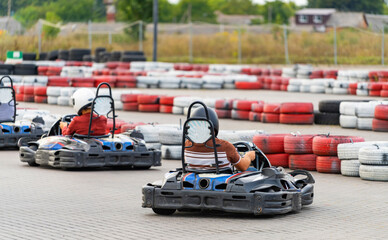 Small kart machines riding. Young karting racer riding on circuit. - obrazy, fototapety, plakaty