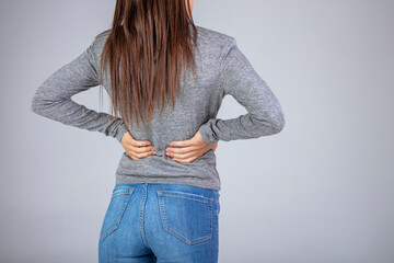 Spine osteoporosis. Scoliosis. Spinal cord problems on woman's back. Attractive female person suffers from backache. All on gray background. Painful back on female body