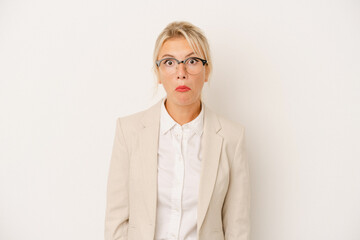 Young business Russian woman isolated on white background shrugs shoulders and open eyes confused.