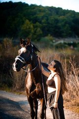 Young girl with horse at summer evening day, sunset light