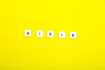 The word BEGIN is written in letters on small white squares on a yellow background.