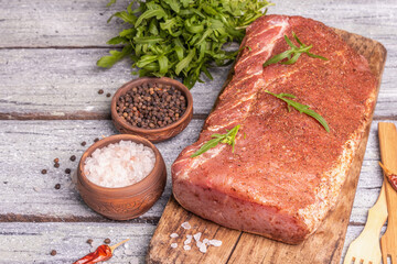 A piece of raw pork loin, marinated fresh meat with spices