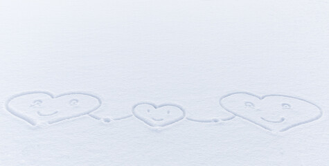 symbolic drawing of three hearts with smiles in snow, two large and one small, holding hands. Friendly family concept. symbol of love, unity, birth of new life for couple in love. Winter joys