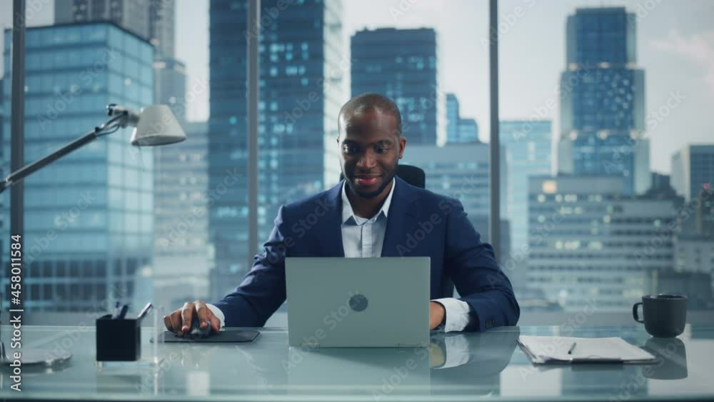 Poster portrait of successful black businessman working on laptop computer in his big city office. smiling 