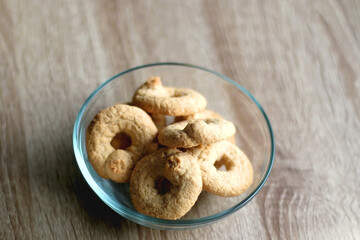 Bowl of biscuits on wooden table. Selective focus.