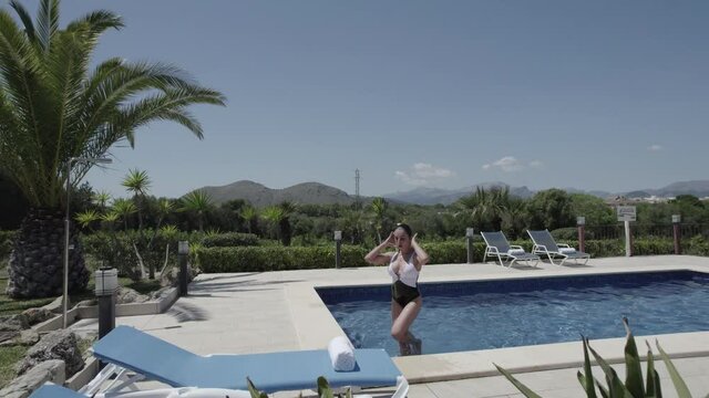 Mujer saliendo de piscina escaleras 2(Formato D-log para edici&oacute;n profesional)