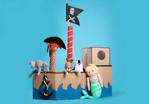 Pirate cardboard ship and toys on turquoise background