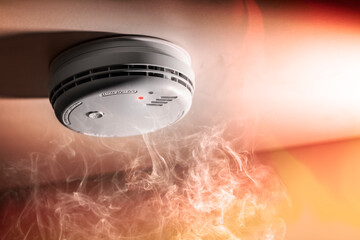 Smoke detector and interlinked fire alarm in action background - 458015176