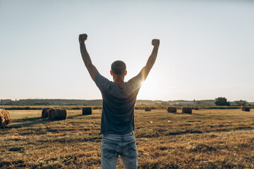 Winning, success and life goals concept. Young man with arms in the air outdoor at sunset time