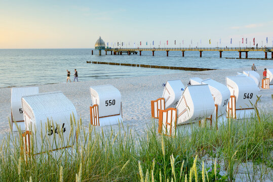 Zingst, Halbinsel Fischland-Dar&szlig;-Zingst, Mecklenburg-Vorpommern, Germany -.View towards Seebr&uuml;cke Zingst from Zingst beach with roofed chair and grass on sand dunes in the foreground.