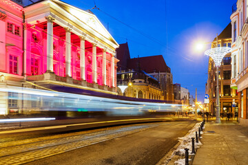 Fototapeta na wymiar tram in a motion blur at night city center and view on theater, Wroclaw, Poland
