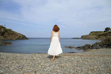 Full body of woman walking contemplating on the beach