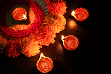 Diwali celebration Indian festival of lights Diya oil lamp and colors Rangoli decoration bright colorful  flowers flowerbed copy space greetings Dipavali Hindu festival North India, Mumbai Delhi India © sanirimpan