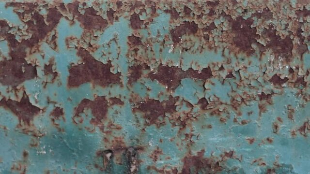 Rusty painted metal surface. Macro view of corrosion in iron metal, texture background. Smooth slow motion. Full HD video footage