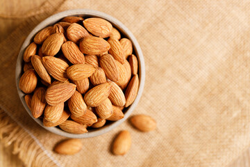 Almonds in a  bowl on wooden table