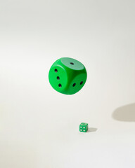 green dice big and small one.white background with shadows.idea concept design