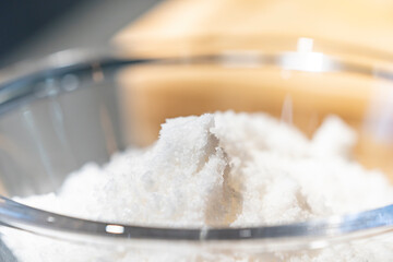Close up to fresh sea salt in glass bowl with low light mood and tone.