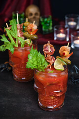 Creepy Halloween party - Caesar or Bloody Mary cocktail containing vodka, some tomato juice, different spices and flavorings, such as Worcestershire sauce, celery. Served with ice in a beer glass 