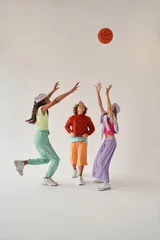Foto auf Leinwand Kids standing isolated over white background and having fun while playing basketball © Yakobchuk Olena