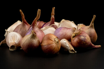 Whole group pile ingredient of fresh onion garlic group isolated on black background